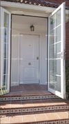 Puerta acorazada vista por la cara exterior con plafón en aluminio lacado blanco.