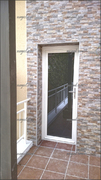 Puerta exterior balconera con la cara exterior en aluminio lacado blanco e interior en madera tecnológica.