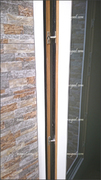 Detalle de la cerradura de puerta exterior balconera, con la cara exterior en aluminio lacado blanco e interior en madera tecnológica.