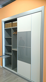 Detalle interior de armario ropero en melamina gris con pantalonero extraible y baldas.