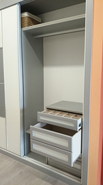  Detalle interior de armario ropero en melamina gris con cajon dividido y gavetero de extracción total.