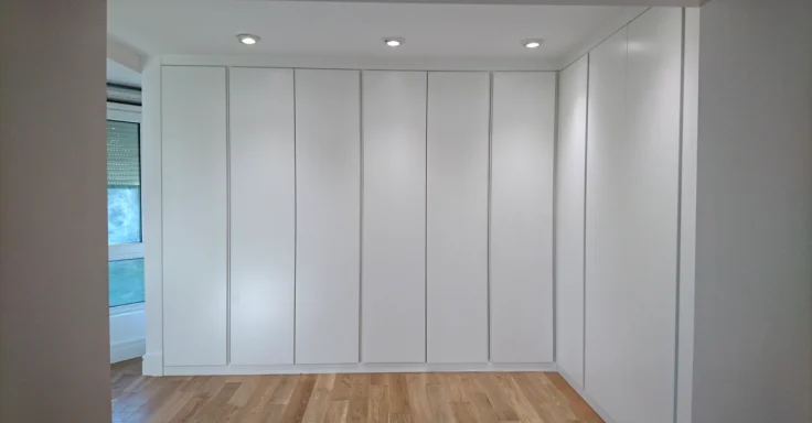 Frente de armario de puertas abatibles lacado en blanco tirador fresado a todo el largo