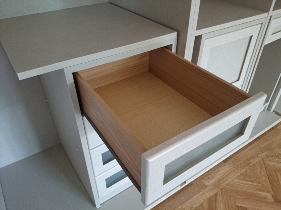 Cajón de madera abierto en un mueble con superficie en melamina lino cancún y acabado elegante. 